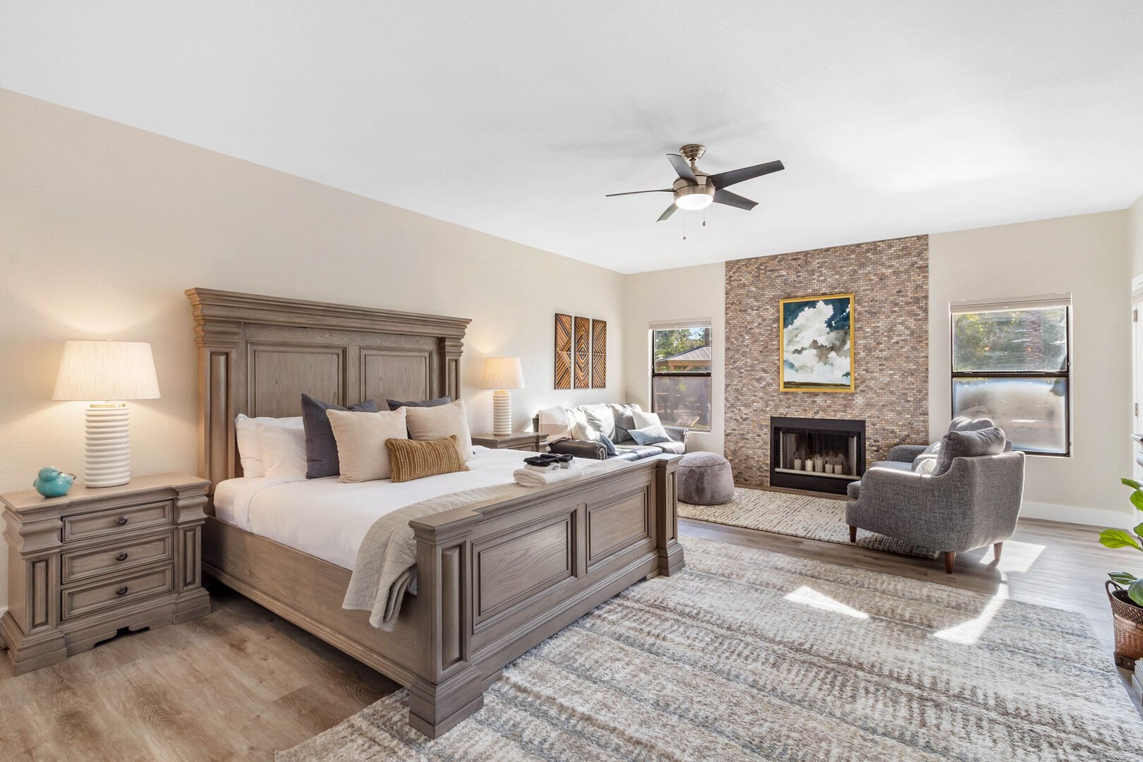 Custom primary suite with sitting area and brick-tiled fireplace