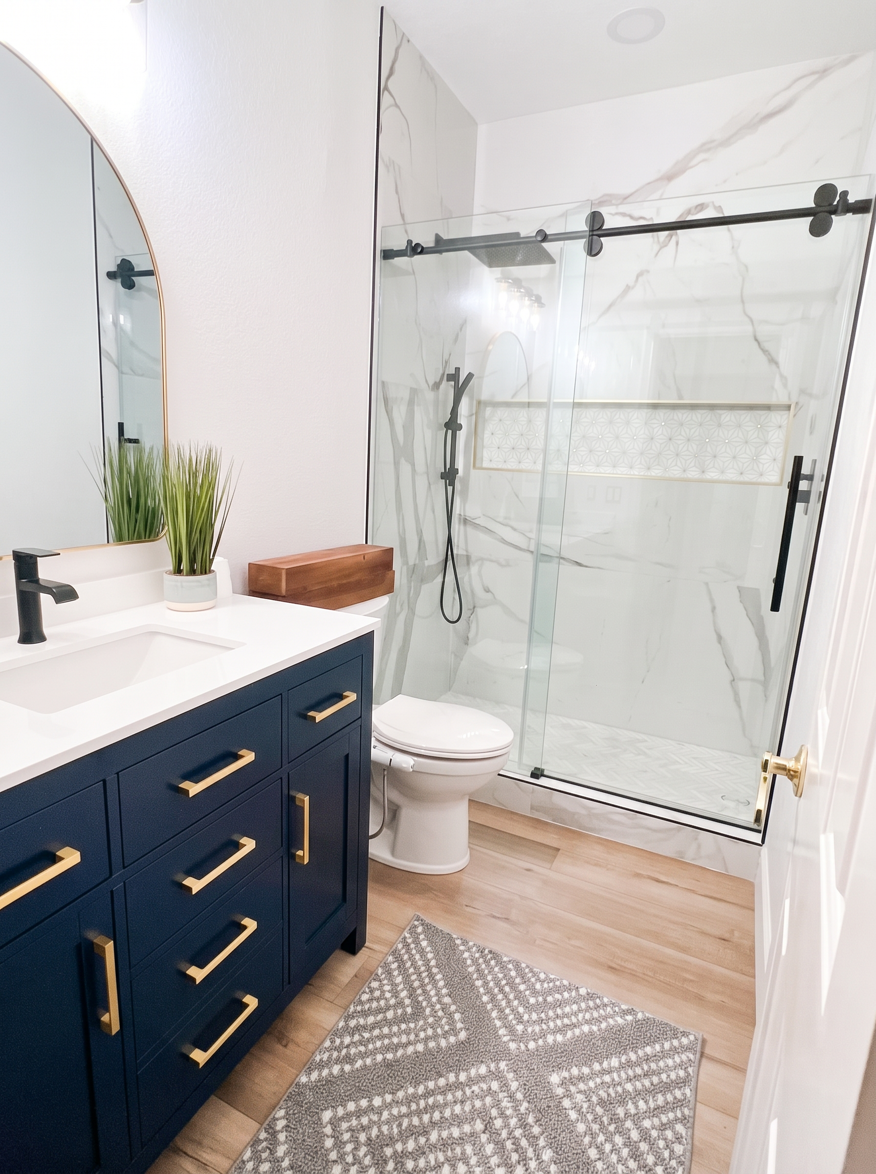 Bathroom remodel with a navy vanity and walk-in tile shower